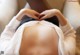 A woman laying on a couch making a heart shape with her hands.