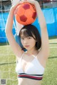 A woman in a white bikini holding a soccer ball.