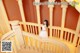 A woman in a white dress standing on a staircase.