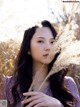 A woman holding a bunch of dry grass in her hands.