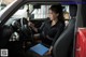 A woman sitting in the driver's seat of a red car.