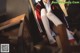 A woman sitting on top of a wooden chair.